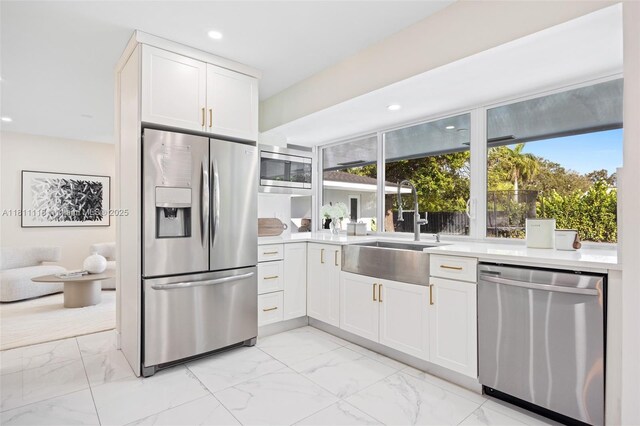 17243 SW 87th Ave, Palmetto Bay, FL 33157 - kitchen featuring appliances with stainless steel finishes, a sink, light marble finish flooring, recessed lighting, and light countertops
