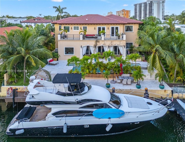 13255 Biscayne Bay Ter, North Miami, FL 33181 - rear view of property featuring a balcony, stucco siding, a tiled roof, a chimney, and a patio