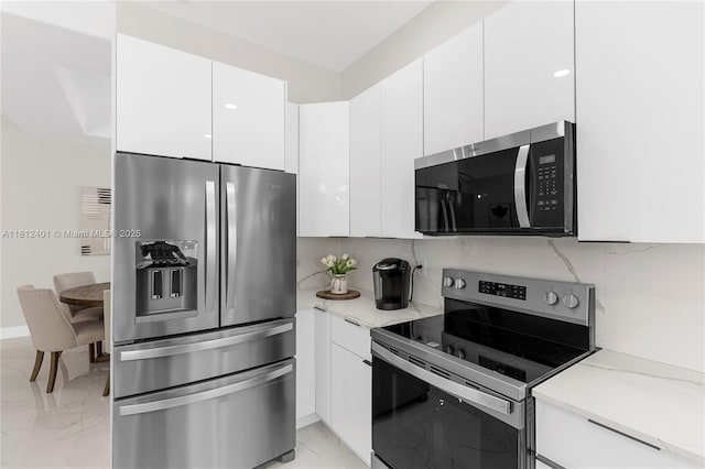 8887 NW 139th Ter, Miami Lakes, FL 33018 - kitchen with appliances with stainless steel finishes, light marble finish flooring, white cabinets, and modern cabinets