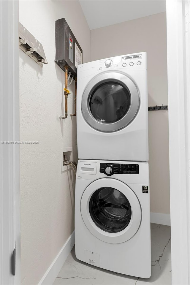 8887 NW 139th Ter, Miami Lakes, FL 33018 - laundry room with stacked washing machine and dryer, marble finish flooring, and baseboards