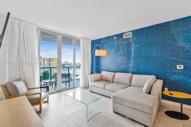 2602 E Hallandale Beach Blvd Unit R1009, Hallandale Beach, FL 33009 - living area with expansive windows, a water view, wallpapered walls, and an accent wall