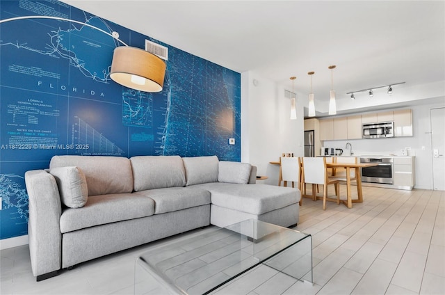 2602 E Hallandale Beach Blvd Unit R1009, Hallandale Beach, FL 33009 - living area featuring an accent wall, wallpapered walls, and track lighting