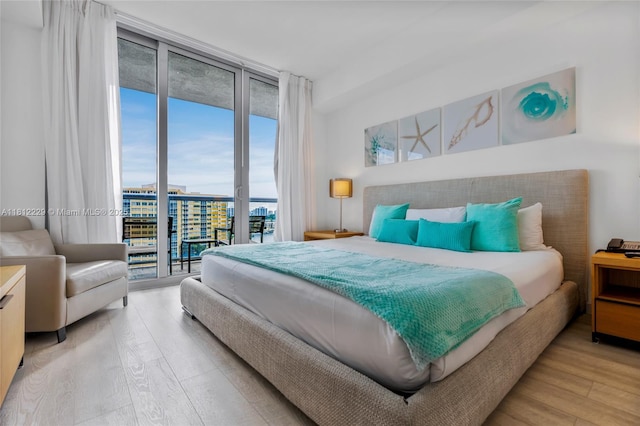 2602 E Hallandale Beach Blvd Unit R1009, Hallandale Beach, FL 33009 - bedroom with a wall of windows, access to exterior, and light wood-style flooring