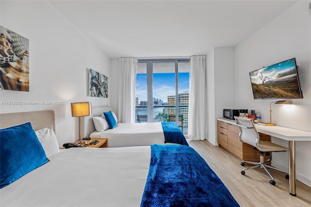 2602 E Hallandale Beach Blvd Unit R1009, Hallandale Beach, FL 33009 - bedroom featuring light wood finished floors, an office area, access to outside, and a wall of windows