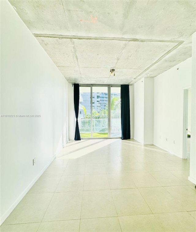 3470 E Coast Ave Unit H1006, Miami, FL 33137 - tiled spare room featuring a wall of windows and baseboards