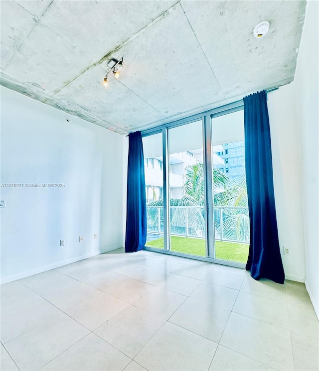 3470 E Coast Ave Unit H1006, Miami, FL 33137 - tiled empty room featuring floor to ceiling windows and baseboards