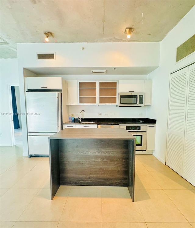 3470 E Coast Ave Unit H1006, Miami, FL 33137 - kitchen featuring appliances with stainless steel finishes, a sink, white cabinets, and light tile patterned floors