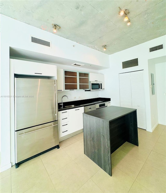 3470 E Coast Ave Unit H1006, Miami, FL 33137 - kitchen with appliances with stainless steel finishes, dark countertops, modern cabinets, open shelves, and white cabinetry