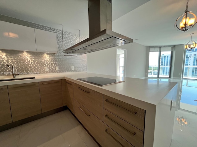 17301 Biscayne Blvd Unit 2105, North Miami Beach, FL 33160 - kitchen featuring wall chimney exhaust hood, black electric stovetop, a sink, a chandelier, and decorative backsplash