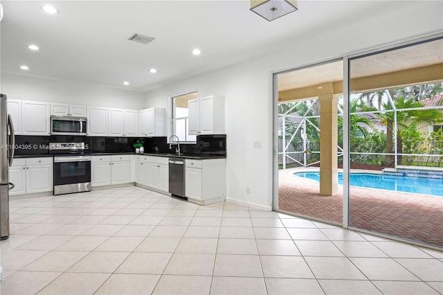 1906 Timberline Rd, Weston, FL 33327 - kitchen with appliances with stainless steel finishes, a sink, decorative backsplash, dark countertops, and healthy amount of natural light