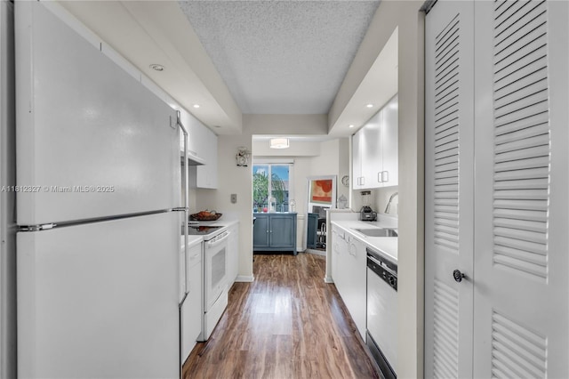801 SW 138th Ave Unit 404E, Pembroke Pines, FL 33027 - kitchen featuring white appliances, wood finished floors, light countertops, a sink, and white cabinetry