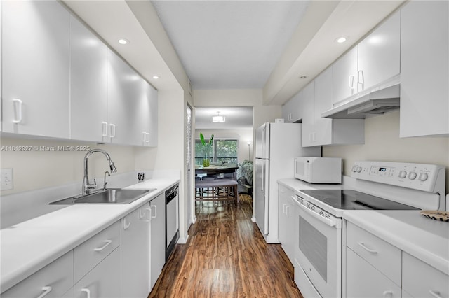 801 SW 138th Ave Unit 404E, Pembroke Pines, FL 33027 - kitchen with white appliances, under cabinet range hood, a sink, dark wood-style floors, and light countertops
