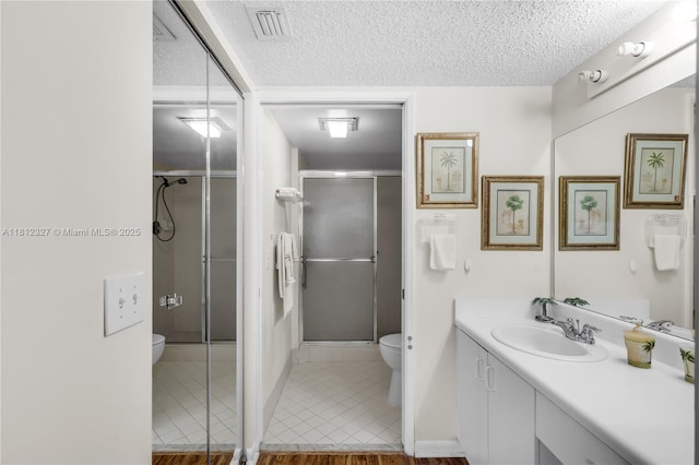 801 SW 138th Ave Unit 404E, Pembroke Pines, FL 33027 - bathroom featuring toilet, vanity, a textured ceiling, a shower stall, and tile patterned flooring