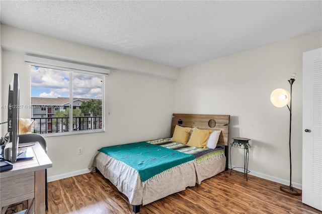 801 SW 138th Ave Unit 404E, Pembroke Pines, FL 33027 - bedroom featuring wood finished floors, baseboards, a textured ceiling, and a desk