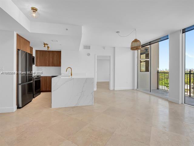 4100 Salzedo St Unit 901, Coral Gables, FL 33146 - kitchen with freestanding refrigerator, modern cabinets, stainless steel range, brown cabinetry, and a sink