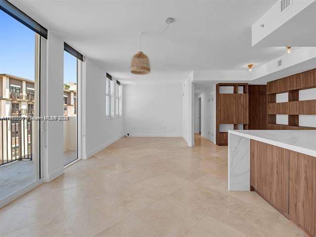 4100 Salzedo St Unit 901, Coral Gables, FL 33146 - kitchen with modern cabinets, light countertops, brown cabinetry, and baseboards