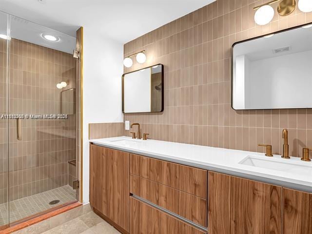 4100 Salzedo St Unit 901, Coral Gables, FL 33146 - bathroom featuring double vanity, a shower stall, decorative backsplash, tile walls, and tile patterned flooring