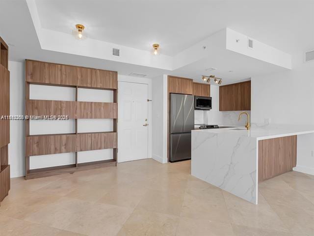 4100 Salzedo St Unit 901, Coral Gables, FL 33146 - kitchen with stainless steel appliances, a raised ceiling, a peninsula, modern cabinets, and brown cabinets