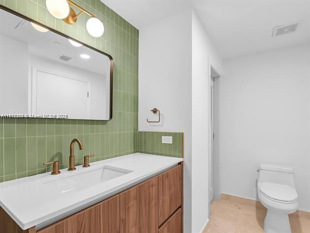 4100 Salzedo St Unit 901, Coral Gables, FL 33146 - bathroom featuring vanity, toilet, decorative backsplash, tile walls, and tile patterned flooring