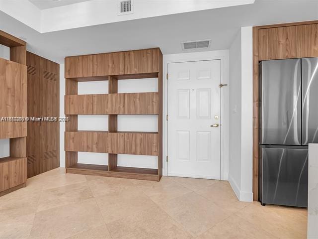 4100 Salzedo St Unit 901, Coral Gables, FL 33146 - kitchen with freestanding refrigerator, brown cabinets, baseboards, light tile patterned floors, and modern cabinets