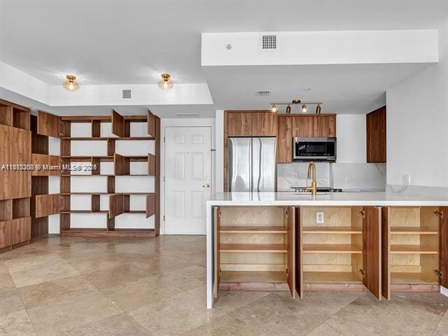 4100 Salzedo St Unit 901, Coral Gables, FL 33146 - kitchen with appliances with stainless steel finishes, open shelves, light countertops, a peninsula, and brown cabinetry