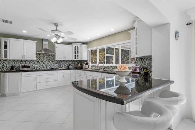 10421 NW 21st St, Pembroke Pines, FL 33026 - kitchen with wall chimney range hood, glass insert cabinets, a sink, backsplash, and a peninsula