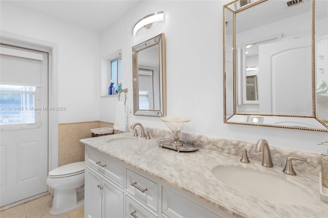 10421 NW 21st St, Pembroke Pines, FL 33026 - bathroom with double vanity, toilet, tile patterned floors, wainscoting, and tile walls
