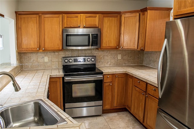 3090 Holiday Springs Blvd Unit 305, Margate, FL 33063 - kitchen with stainless steel appliances, a sink, tile countertops, and backsplash