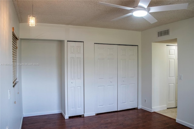 3090 Holiday Springs Blvd Unit 305, Margate, FL 33063 - unfurnished bedroom featuring wood finished floors, a textured ceiling, multiple closets, baseboards, and ceiling fan