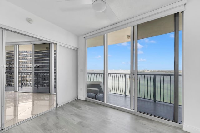 1750 N Bayshore Dr Unit 4801, Miami, FL 33132 - unfurnished room with expansive windows, plenty of natural light, wood finished floors, ceiling fan, and a water view