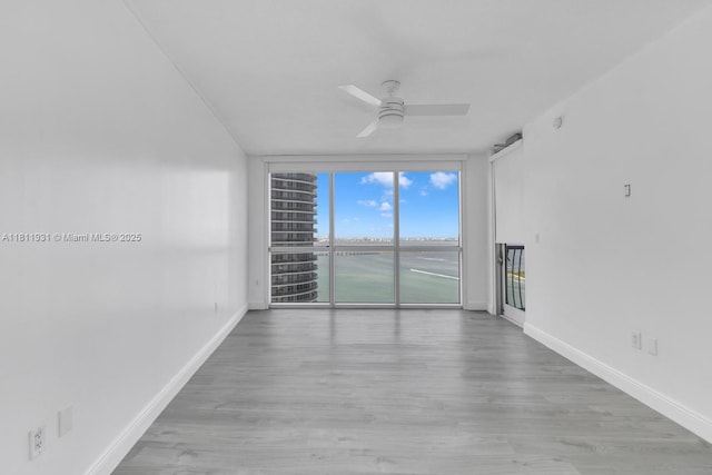1750 N Bayshore Dr Unit 4801, Miami, FL 33132 - spare room with a ceiling fan, baseboards, expansive windows, and wood finished floors