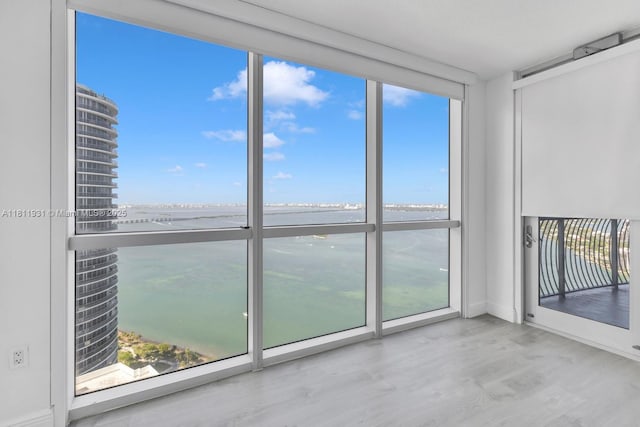 1750 N Bayshore Dr Unit 4801, Miami, FL 33132 - unfurnished room with a water view, healthy amount of natural light, wood finished floors, and floor to ceiling windows