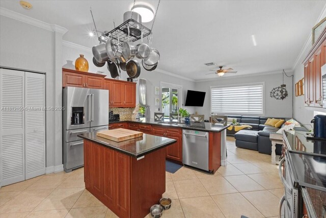 18342 NW 11th St, Pembroke Pines, FL 33029 - kitchen featuring appliances with stainless steel finishes, a peninsula, open floor plan, crown molding, and light tile patterned floors
