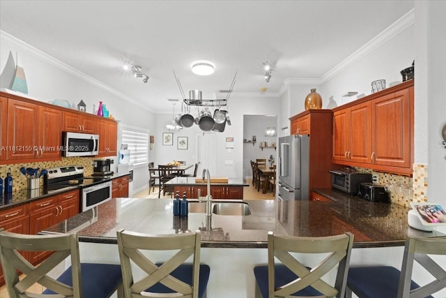 18342 NW 11th St, Pembroke Pines, FL 33029 - kitchen with appliances with stainless steel finishes, a sink, decorative backsplash, ornamental molding, and a kitchen bar