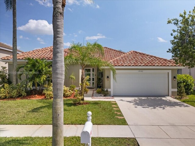 18342 NW 11th St, Pembroke Pines, FL 33029 - mediterranean / spanish home with a garage, stucco siding, a tiled roof, a front yard, and driveway