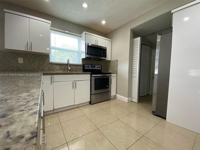 7521 Granada Blvd, Miramar, FL 33023 - kitchen with stainless steel appliances, tasteful backsplash, a sink, white cabinets, and recessed lighting