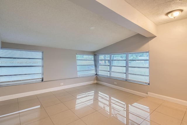 7521 Granada Blvd, Miramar, FL 33023 - empty room with a textured ceiling, light tile patterned flooring, baseboards, and vaulted ceiling