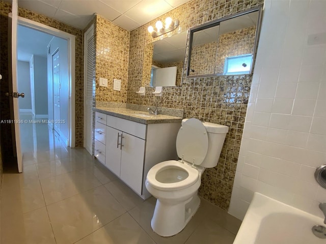 7521 Granada Blvd, Miramar, FL 33023 - bathroom with tile walls, tile patterned flooring, a tub to relax in, vanity, and toilet