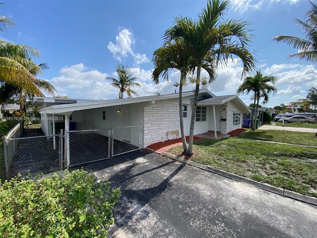 7521 Granada Blvd, Miramar, FL 33023 - view of front facade featuring a gate, asphalt driveway, and a carport