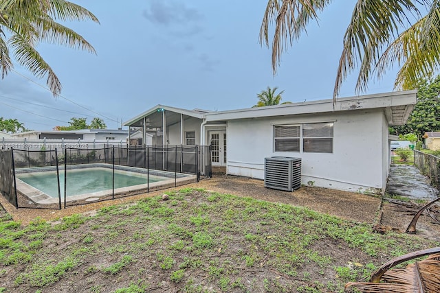 7521 Granada Blvd, Miramar, FL 33023 - rear view of property featuring central AC unit, a sunroom, a fenced backyard, and stucco siding