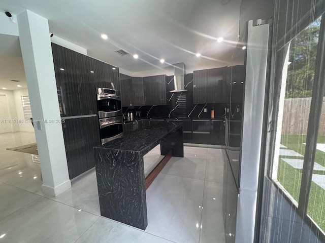 10003 NW 89th Ter, Doral, FL 33178 - kitchen featuring modern cabinets, stainless steel double oven, dark cabinets, a kitchen island, and wall chimney exhaust hood