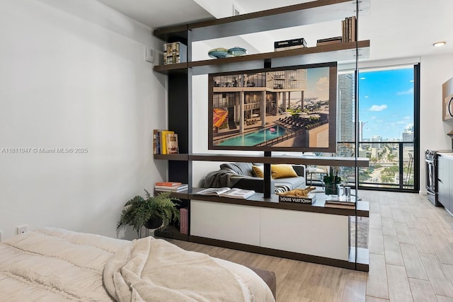 398 NE 5th St Unit 2704, Miami, FL 33132 - bedroom with a wall of windows, light wood-style flooring, and a city view
