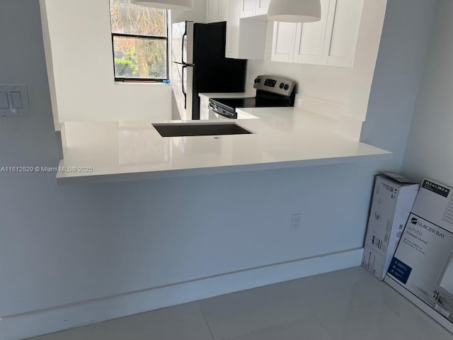5200 NW 31st Ave Unit 14, Fort Lauderdale, FL 33309 - kitchen featuring electric stove, white cabinets, freestanding refrigerator, and light countertops