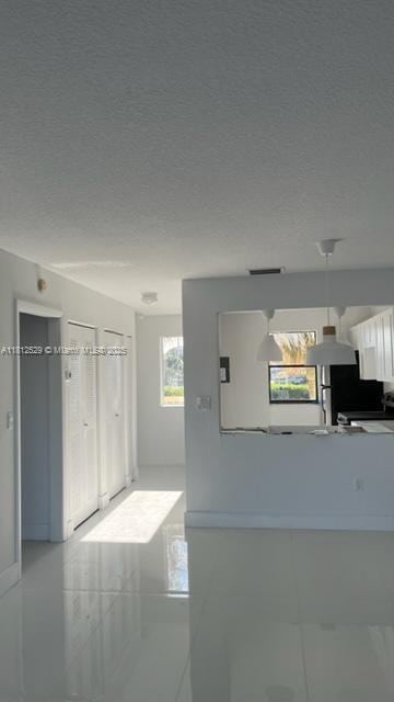5200 NW 31st Ave Unit 14, Fort Lauderdale, FL 33309 - hall featuring tile patterned floors and a textured ceiling