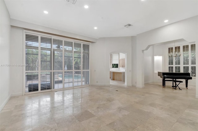 8244 Lakeview Dr, West Palm Beach, FL 33412 - unfurnished living room featuring arched walkways, baseboards, and recessed lighting