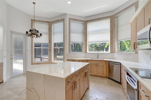 8244 Lakeview Dr, West Palm Beach, FL 33412 - kitchen with stainless steel appliances, a sink, light stone counters, a chandelier, and decorative backsplash