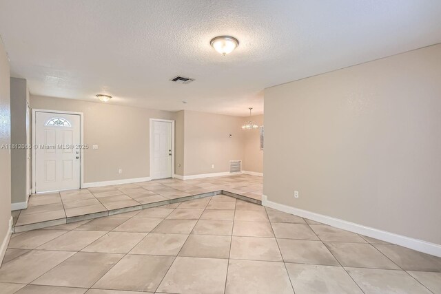9353 SW 1st Pl, Boca Raton, FL 33428 - unfurnished room featuring light tile patterned floors, a textured ceiling, a chandelier, and baseboards