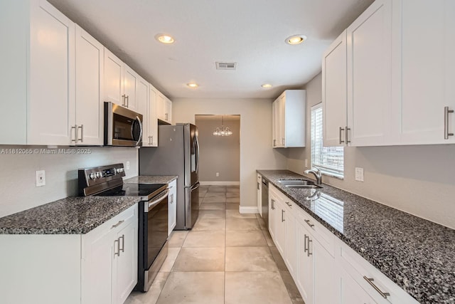 9353 SW 1st Pl, Boca Raton, FL 33428 - kitchen featuring stainless steel appliances, a sink, white cabinets, a chandelier, and dark stone counters