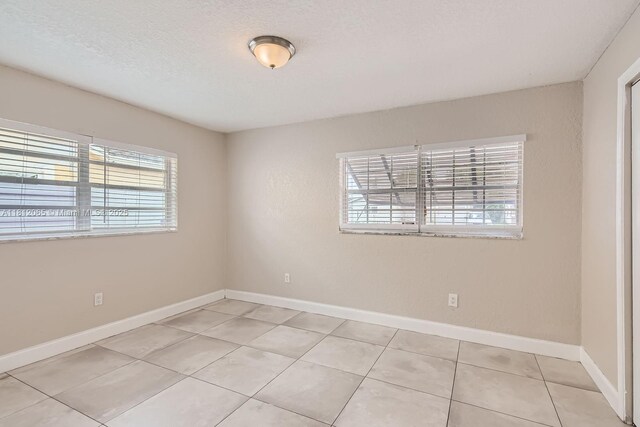 9353 SW 1st Pl, Boca Raton, FL 33428 - spare room featuring healthy amount of natural light, light tile patterned flooring, and baseboards