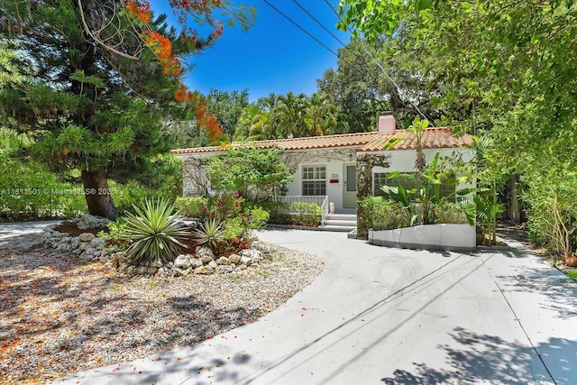 8538 NE 4th Ave, El Portal, FL 33138 - mediterranean / spanish home with a tiled roof, a chimney, and stucco siding